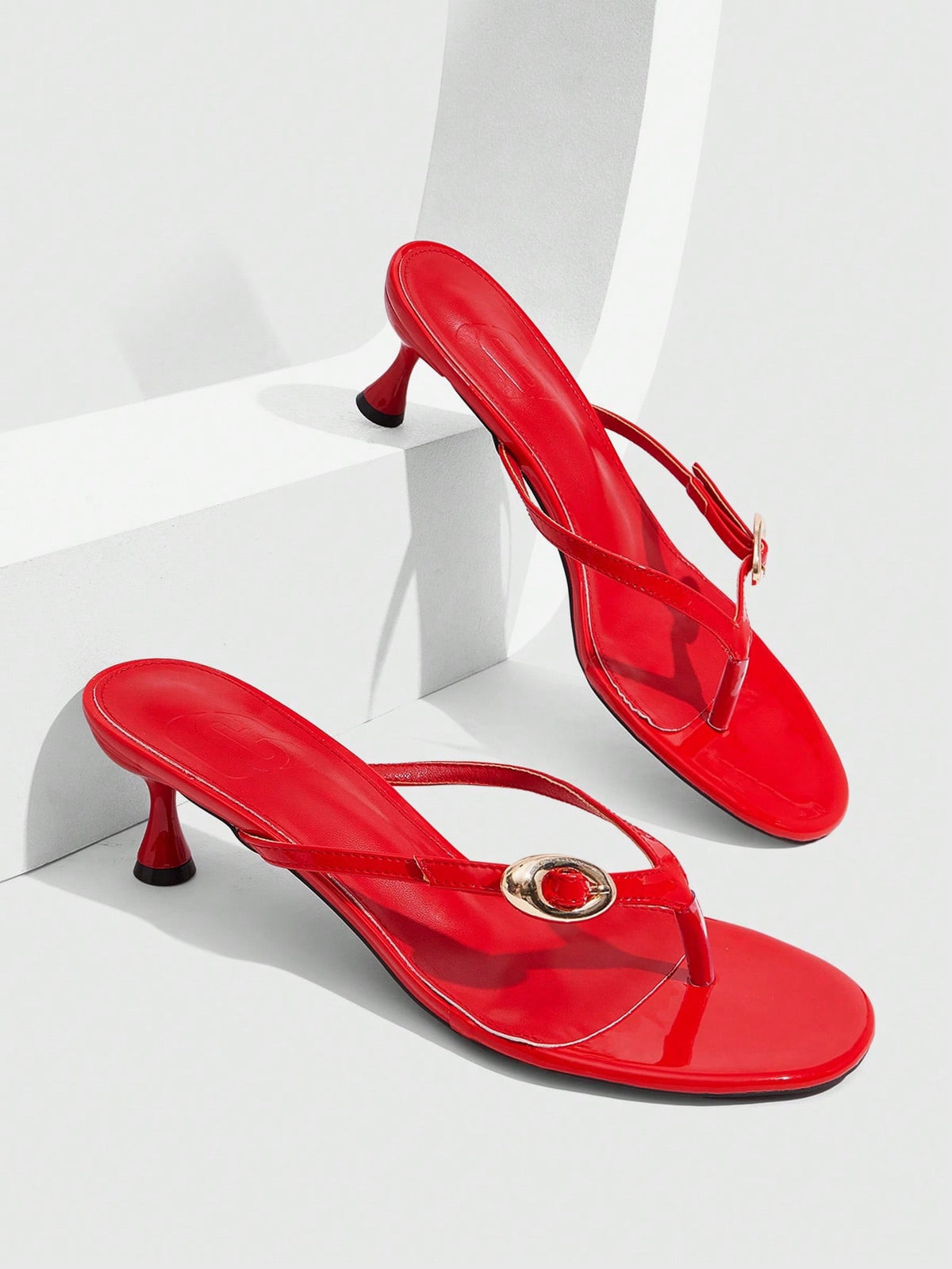 Women's slingback heeled sandals featuring a button toe post accent, sleek mid pyramid heel, and smooth faux leather finish.