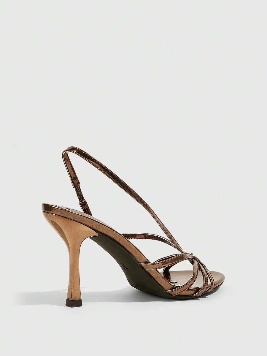 Women's open-toed stiletto high-heeled sandals in glossy patent black featuring twist strap detailing and slingback design.