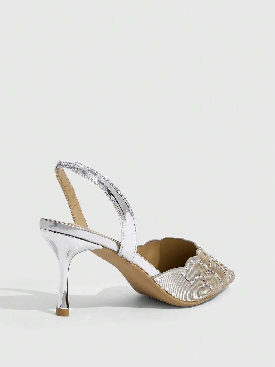 Pair of women's silver glitter pointed party heels with slingback straps, rhinestone accents, and stiletto heels.