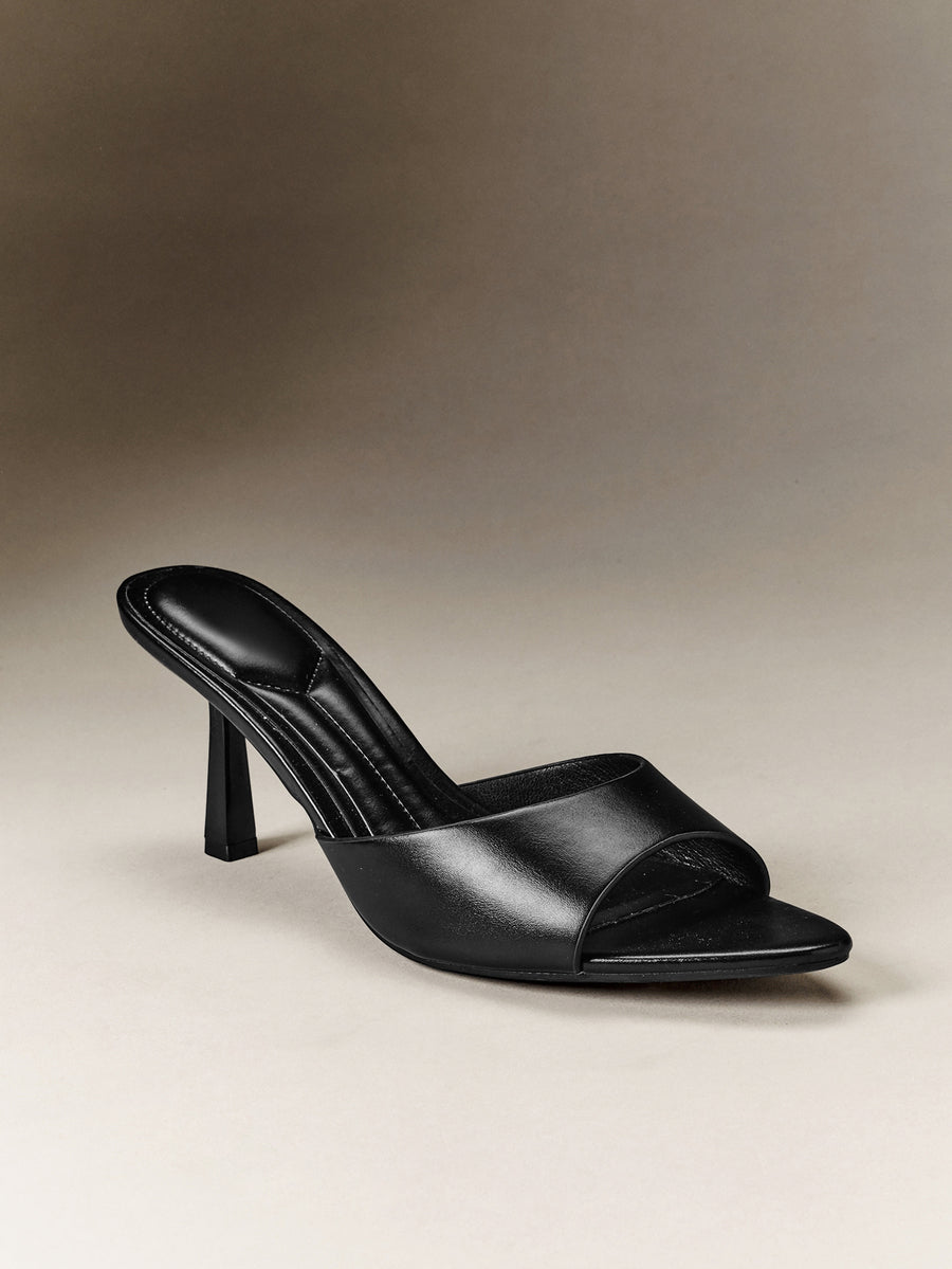 Pair of women's minimalist black pointy toe stiletto heel sandals with slingback straps.