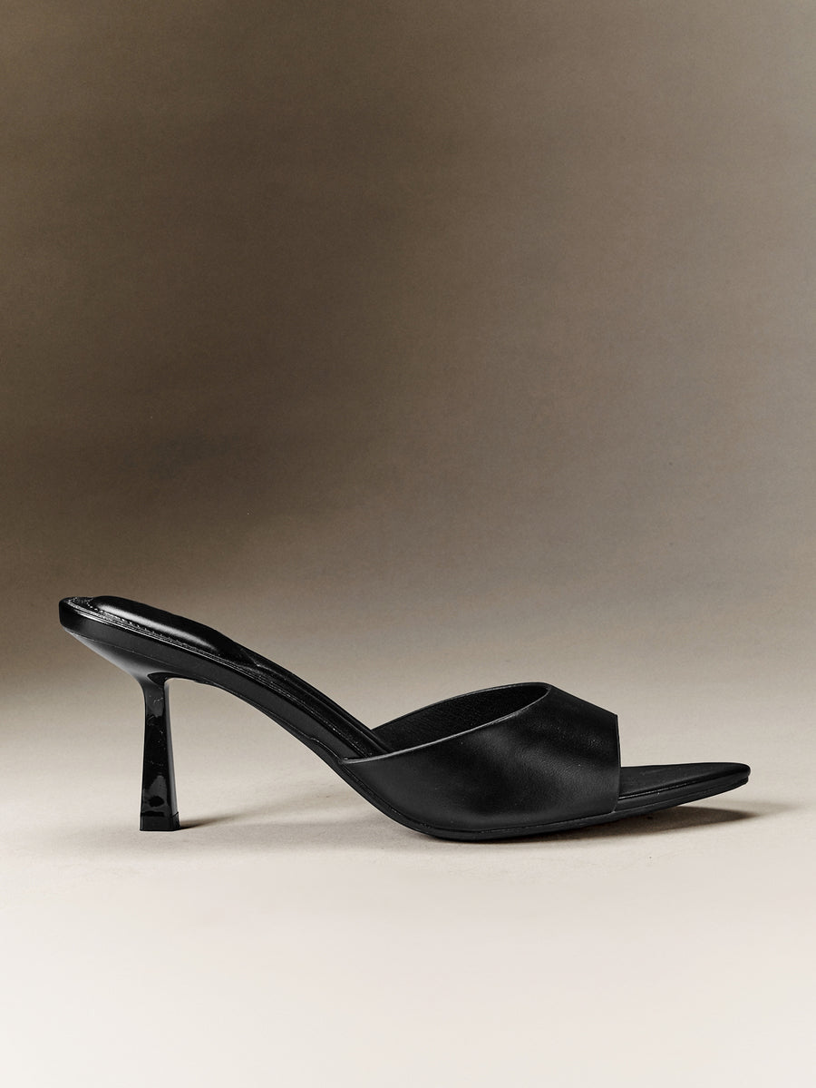 Pair of women's minimalist black pointy toe stiletto heel sandals with slingback straps.